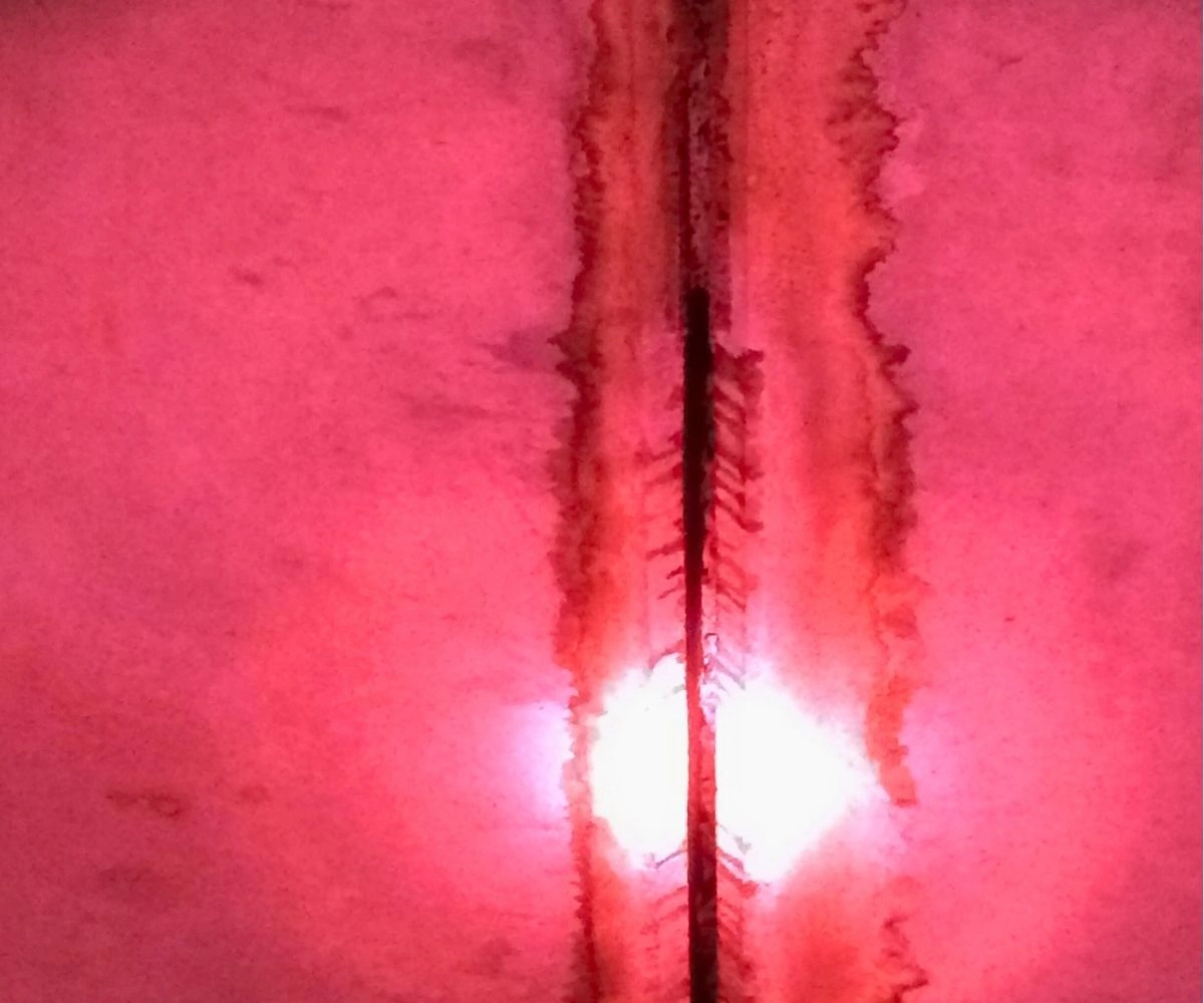 a crack under the bridge with tons of bats inside of it