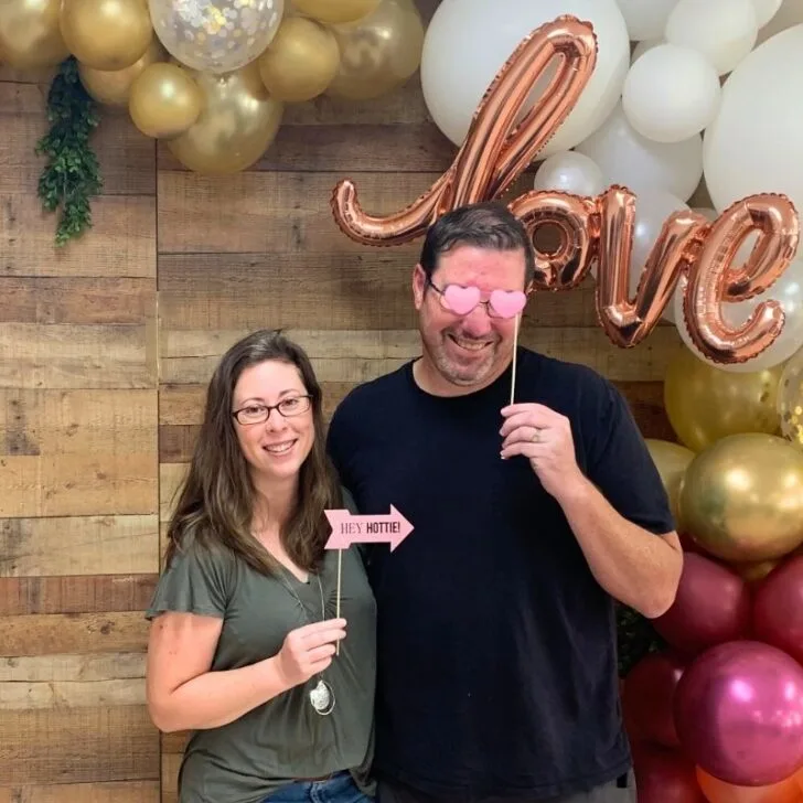 blogger and her husband holding up cute signs taking couples photo at church marriage seminar