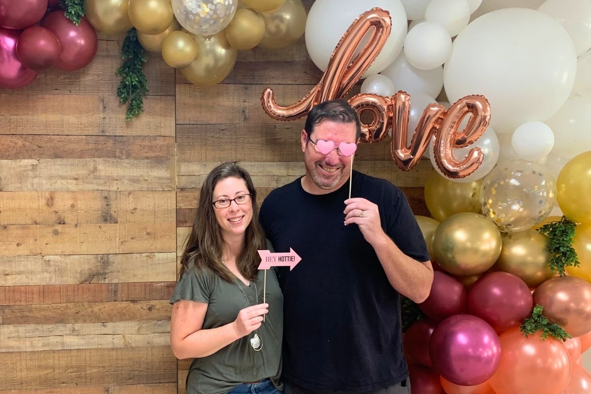 blogger and her husband holding up cute signs taking couples photo at church marriage seminar