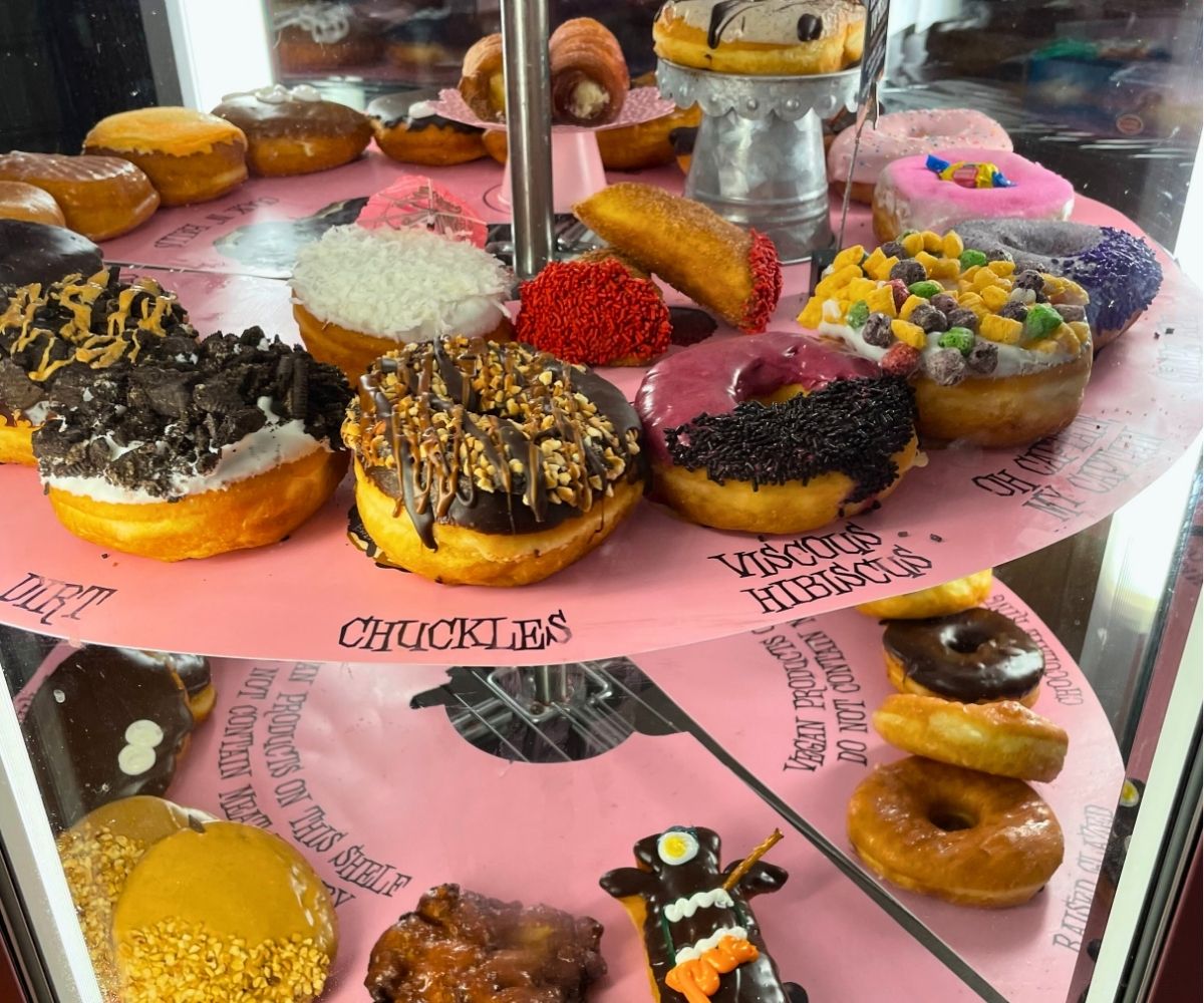 two tiers of decadent donuts at donut shop