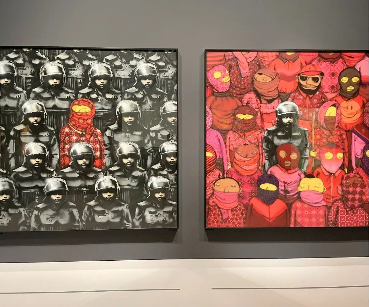 two huge paintings by banksy hanging on wall