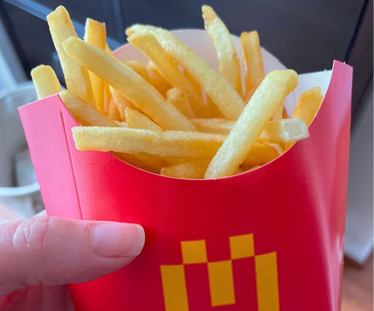 woman holding medium-sized McDonald's fries box