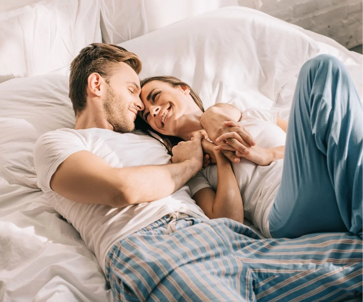 couple snuggling in their guest bedroom