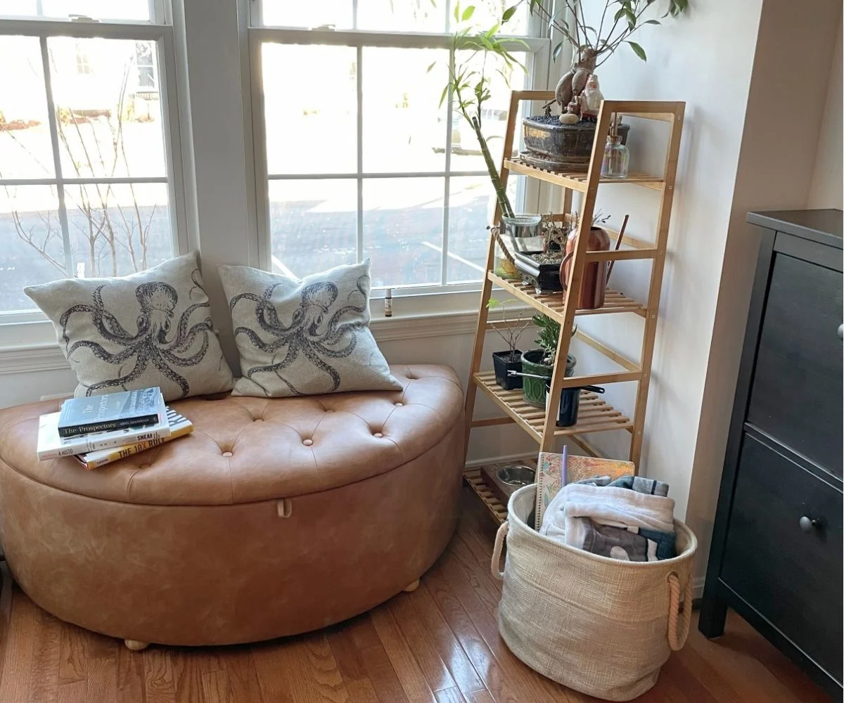 leather brown bench semi-circle with two Octopus pillows next to ladder planter and some books in kitchen
