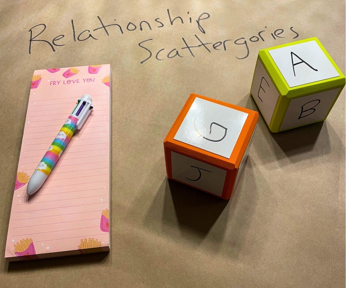 relationship scattergories with two dry erase dice with letters on it, and a big pad of paper