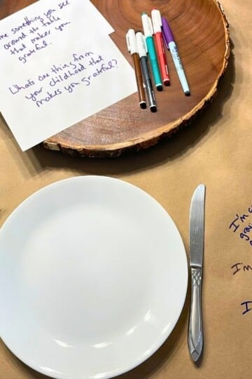 plate setting on butcher paper with handwritten gratefulness questions and markers on table