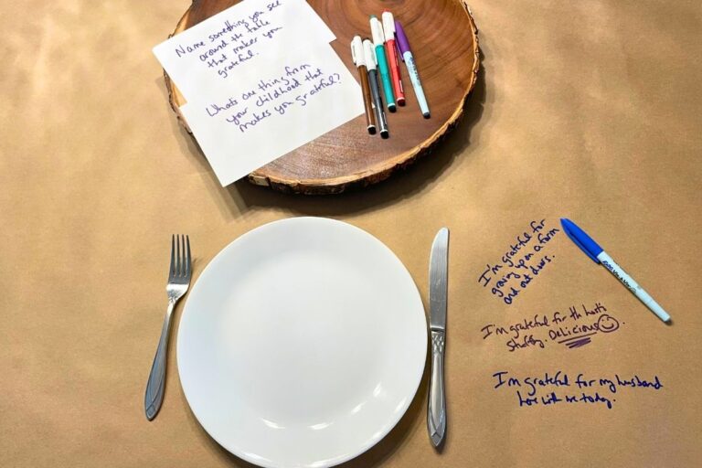 plate setting on butcher paper with handwritten gratefulness questions and markers on table