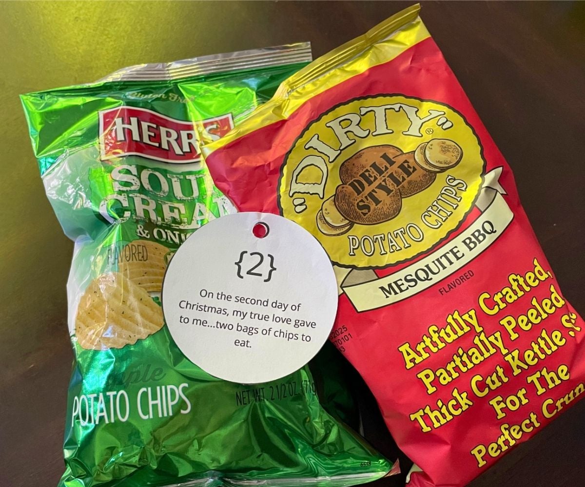 a red and a green bag of chips with ornament tag on dark table