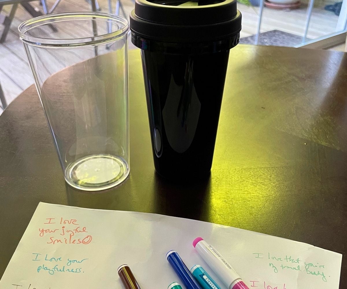 colorful pens on top of white paper and inside of cup shown where paper will go