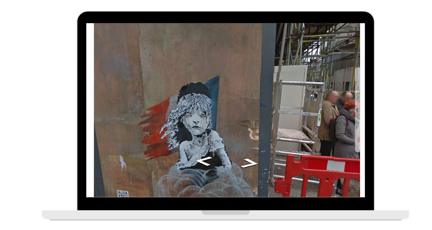 laptop screen showing Banksy exhibit at french embassy in London