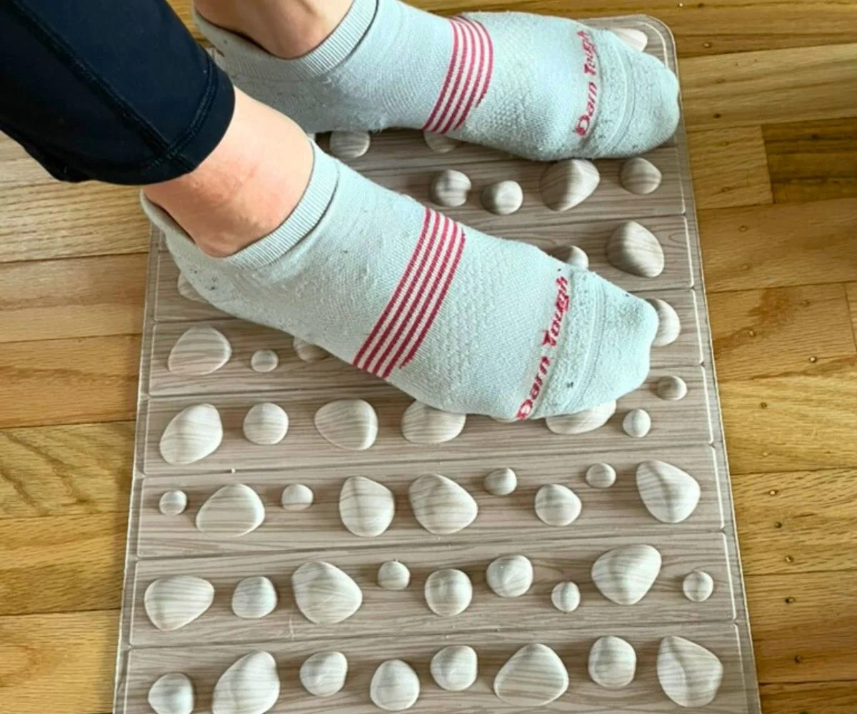 woman's feet in socks on pebbled accupressure mat