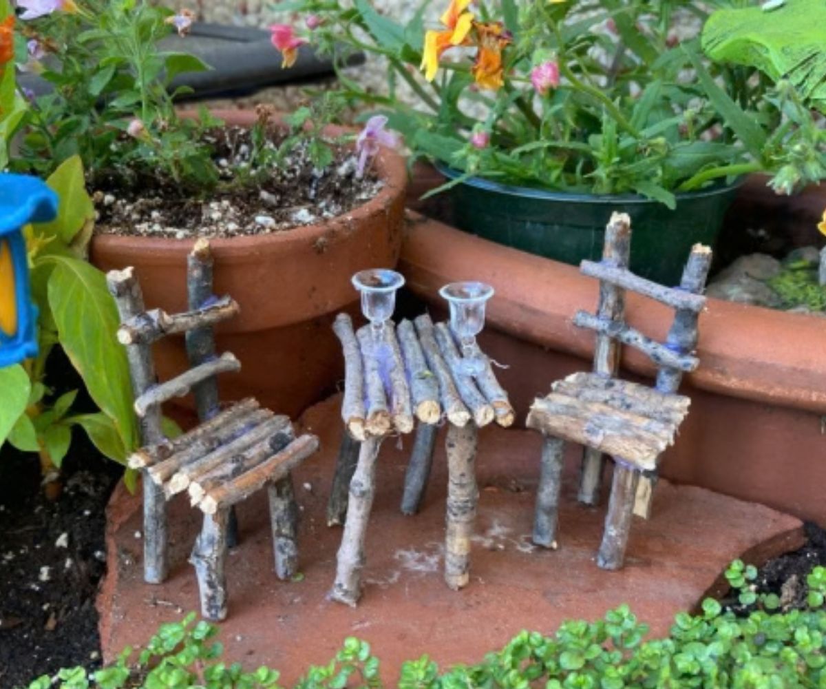 adorable tiny fairy chairs and table made out of twigs in the fairy garden