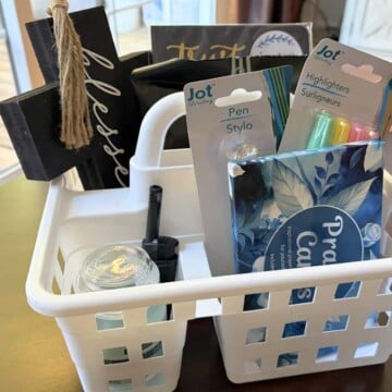 Bible studying supplies in a white shower caddy on dark table