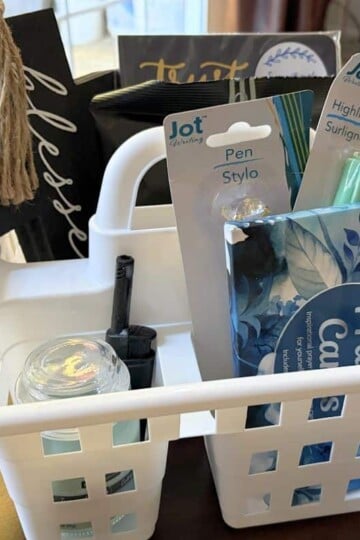 Bible studying supplies in a white shower caddy on dark table