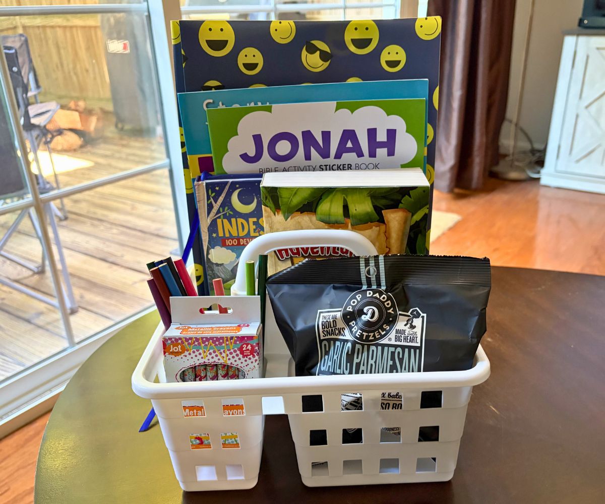 white caddy Bible Study Station for kids filled with colored pencils, crayons, Kid Adventure Bible, Bible study coloring books, and a snack