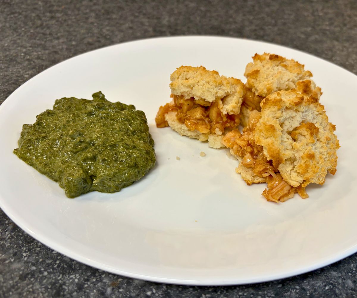 chicken BBQ stuffed biscuits with creamed spinach on the side on white plate