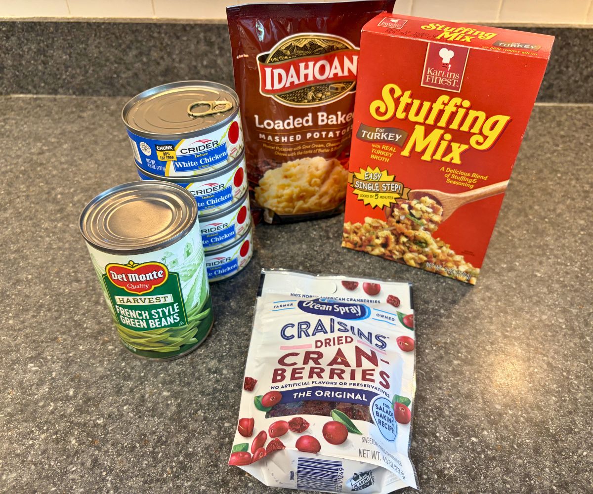 box of stuffing mix, instant mashed potatoes bag, four cans of chicken, can of french style green beans, and bag of craisins