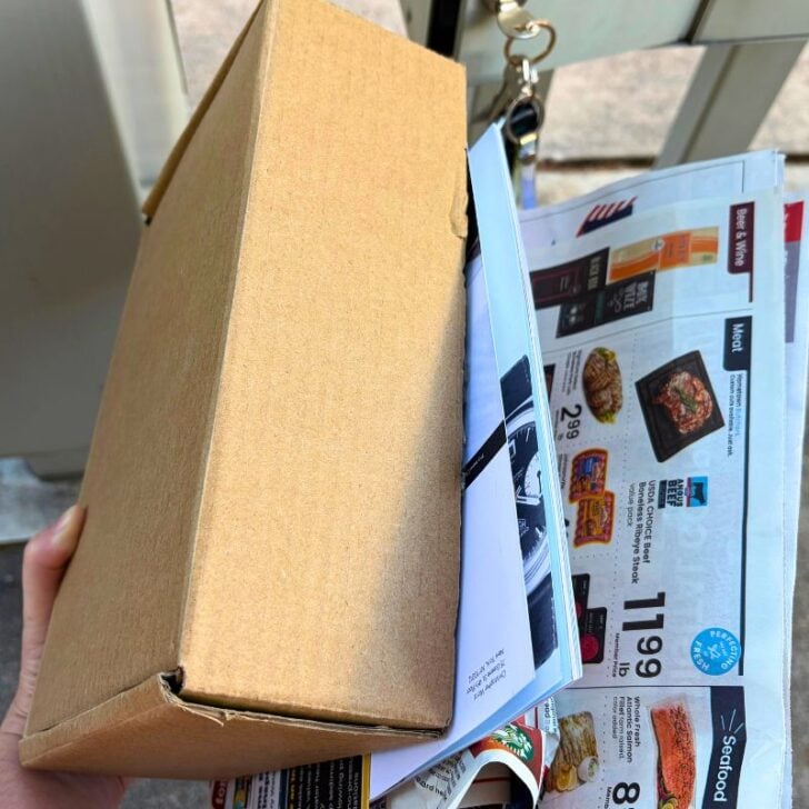 woman getting free box of beauty samples by mailbox